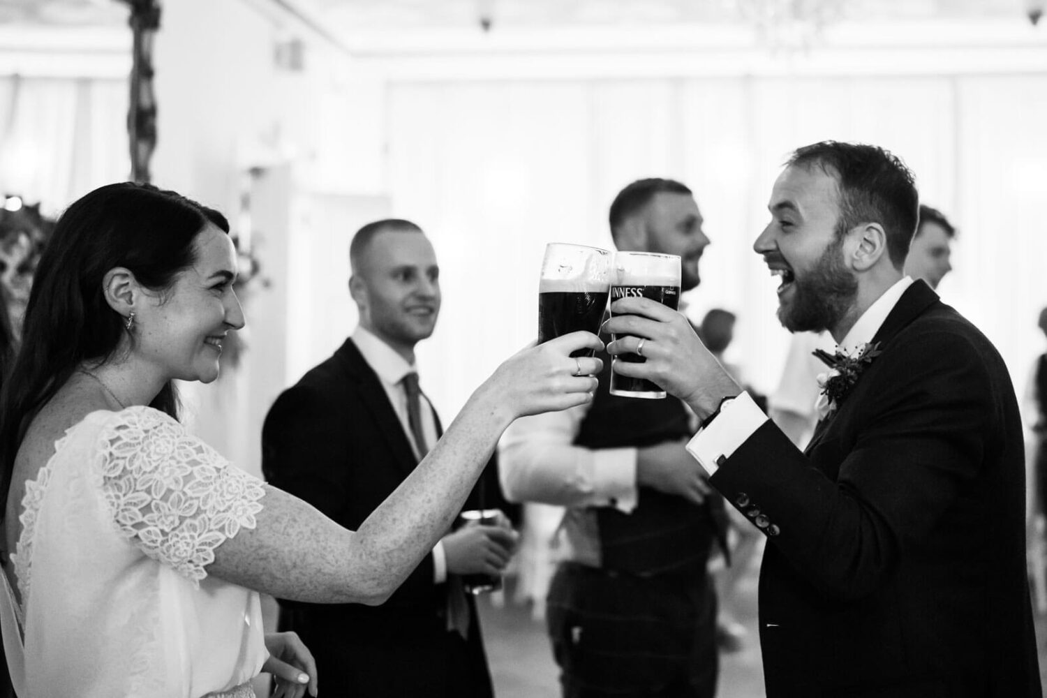 bride and groom saying cheers with their pints