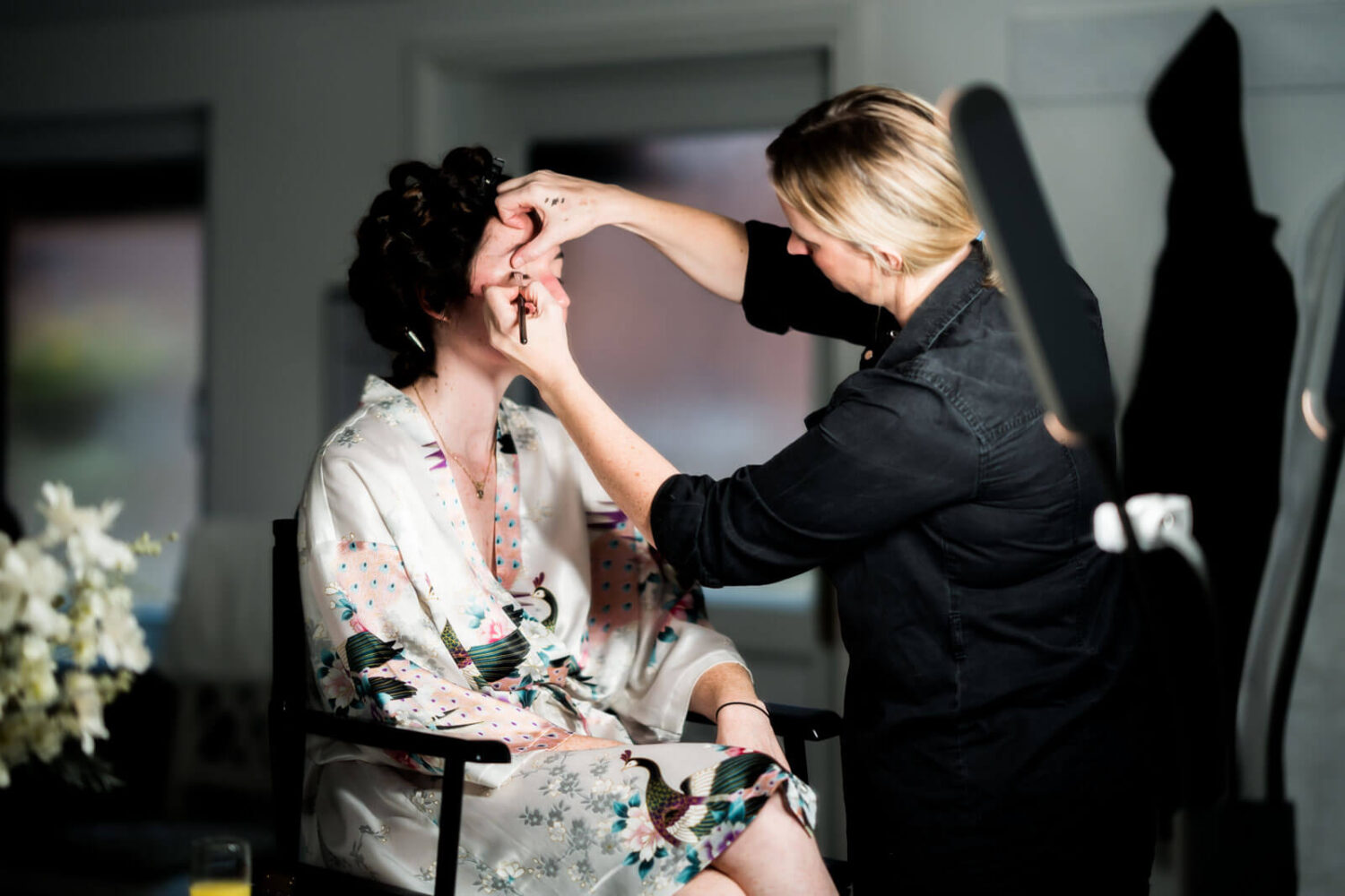 bride and make up artist doing eye make up at highley manor
