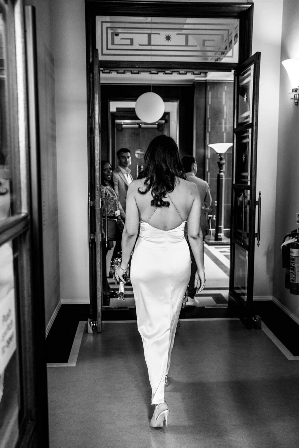 bride walking away from camera towards ceremony room london wedding