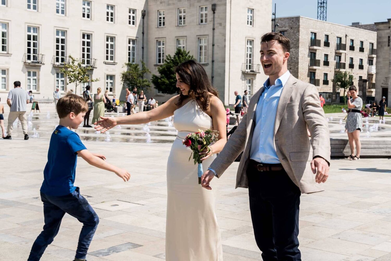 bride and groom arms out welcoming nephew for a hug london wedding