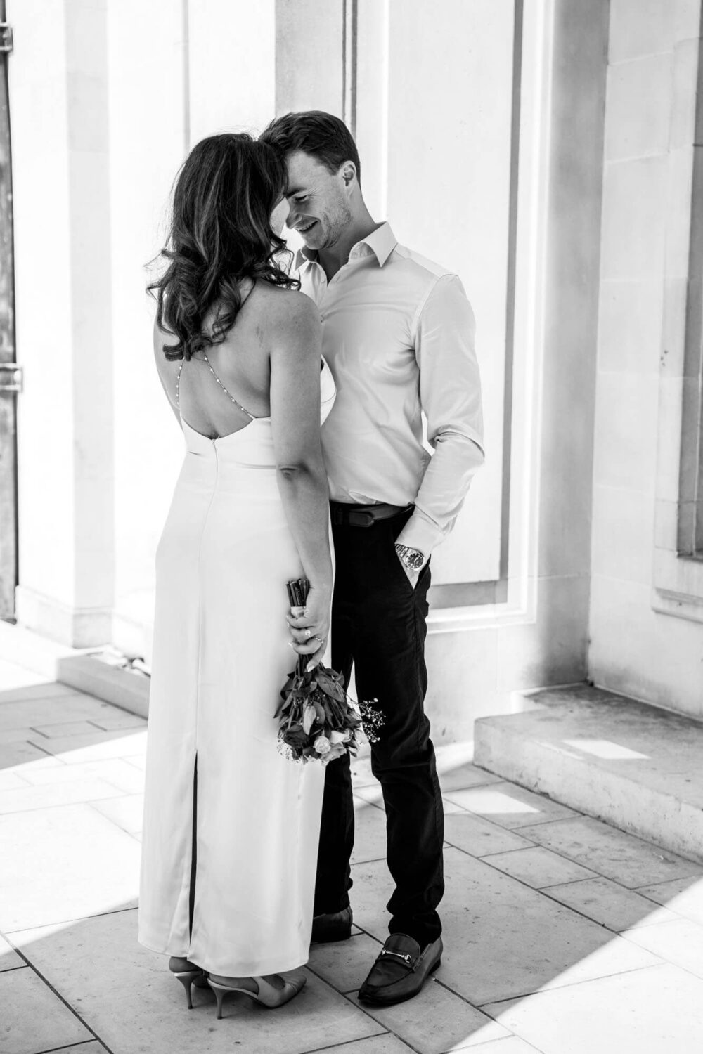 bride back to camera groom hand in pocket up close to his wife london wedding