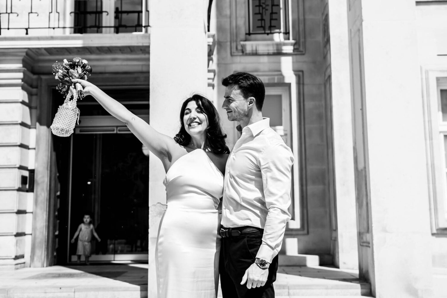 bride holding up her flowers in celebration london wedding