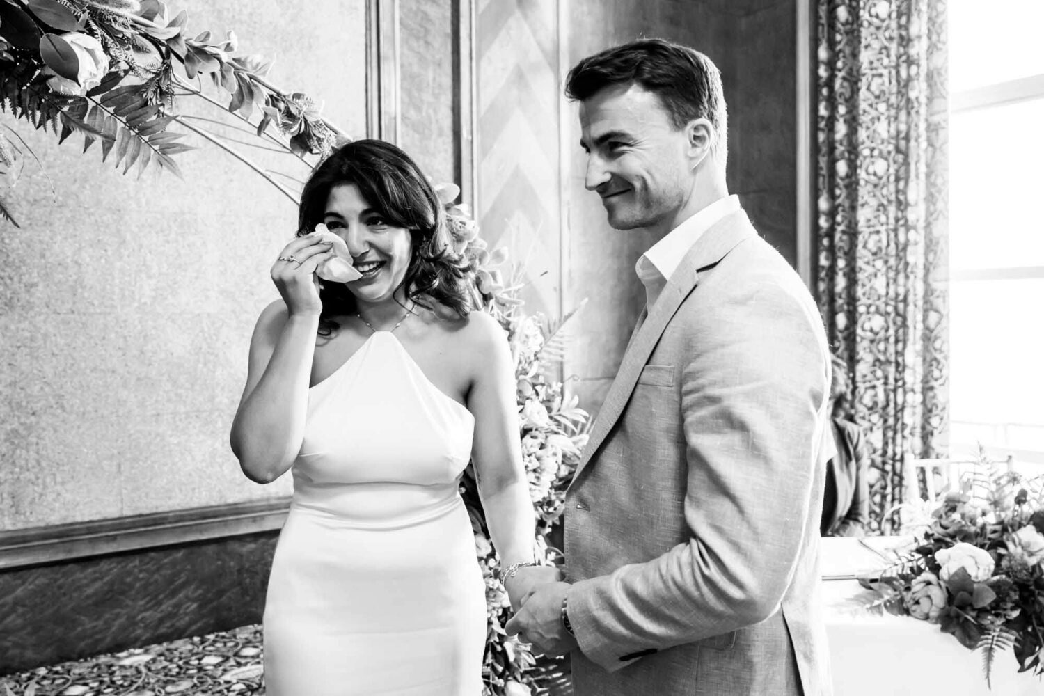 bride wiping away a tear holding hands with husband london wedding