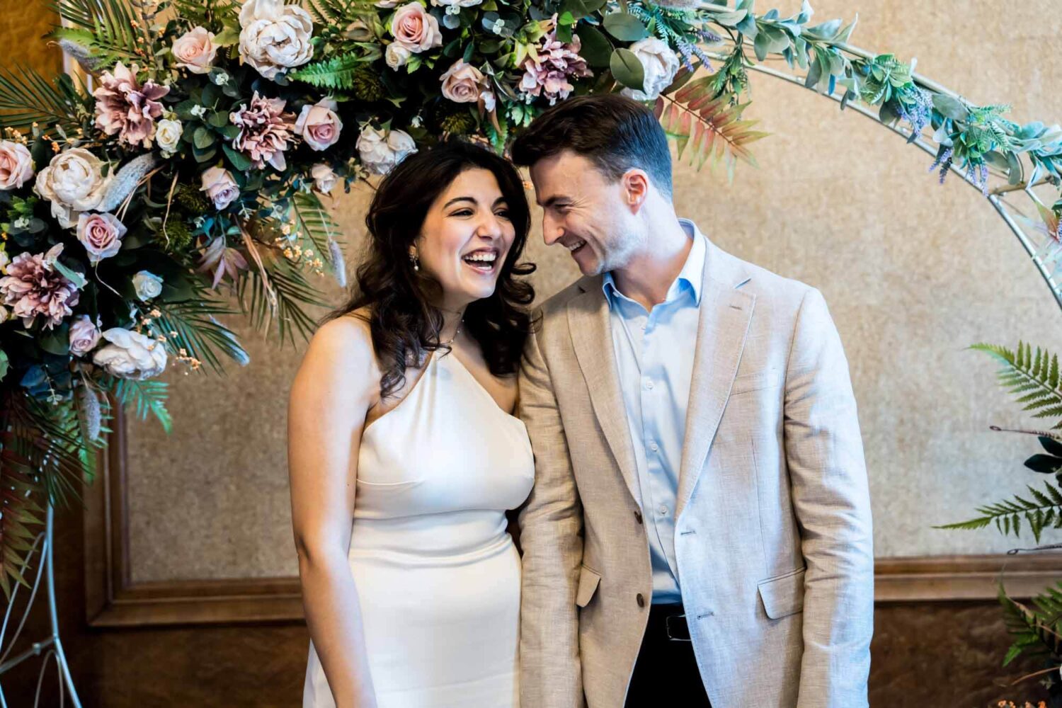 groom smiling looking at bride as she laughs london wedding