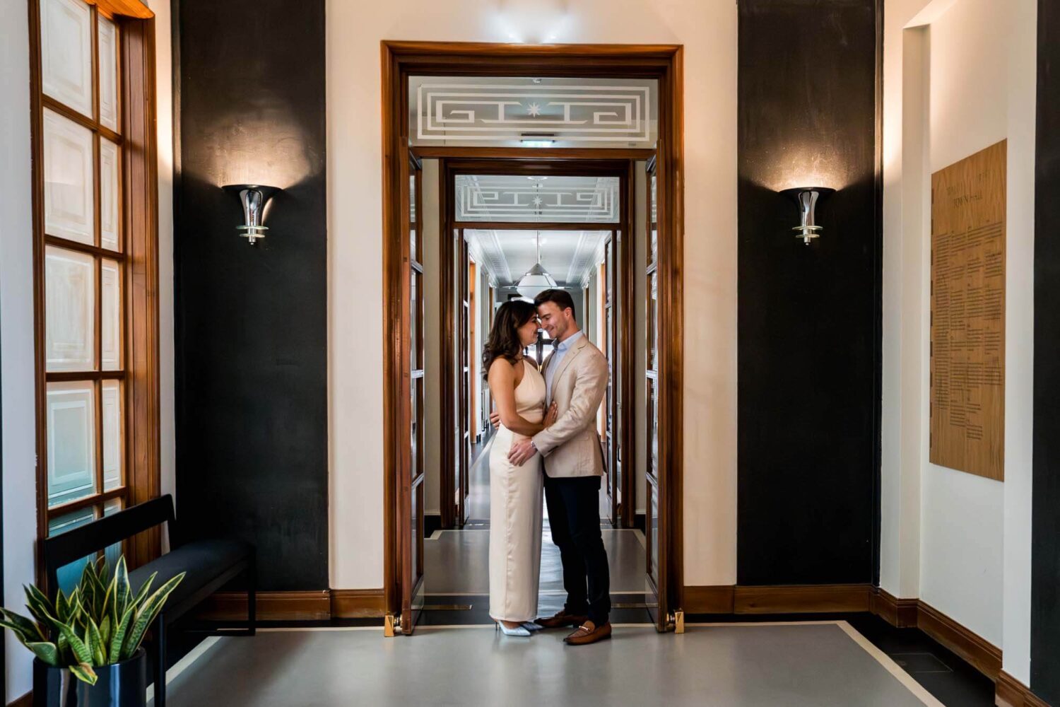 bride and groom stand under doorway looking at each other london wedding