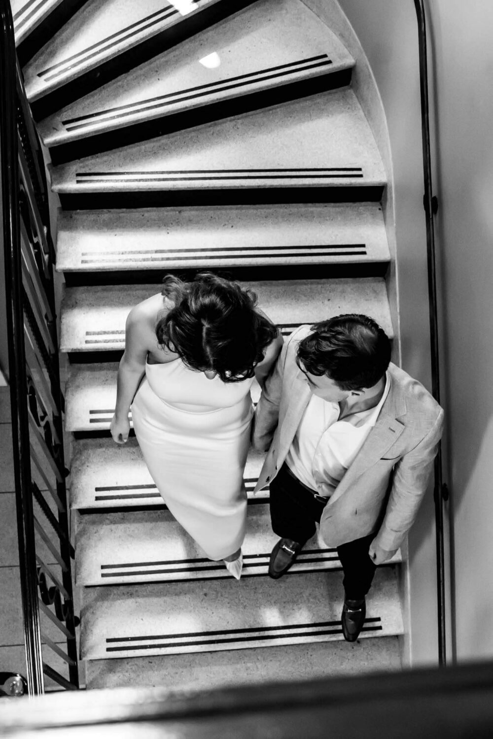 bride and groom walking down the stairs taking from up high london wedding