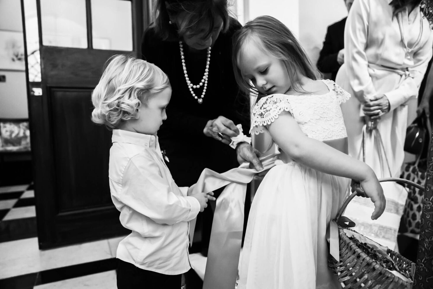 bridesmaid having dress bow fixed by brother london wedding