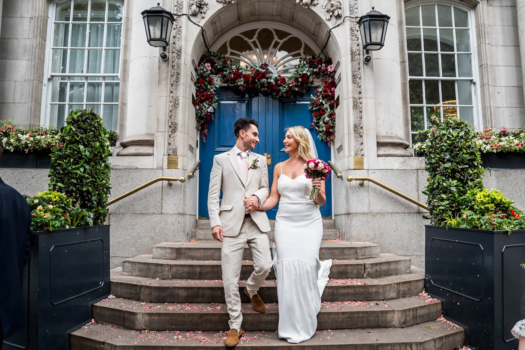 bride and groom walking down famous chelsea town hall steps