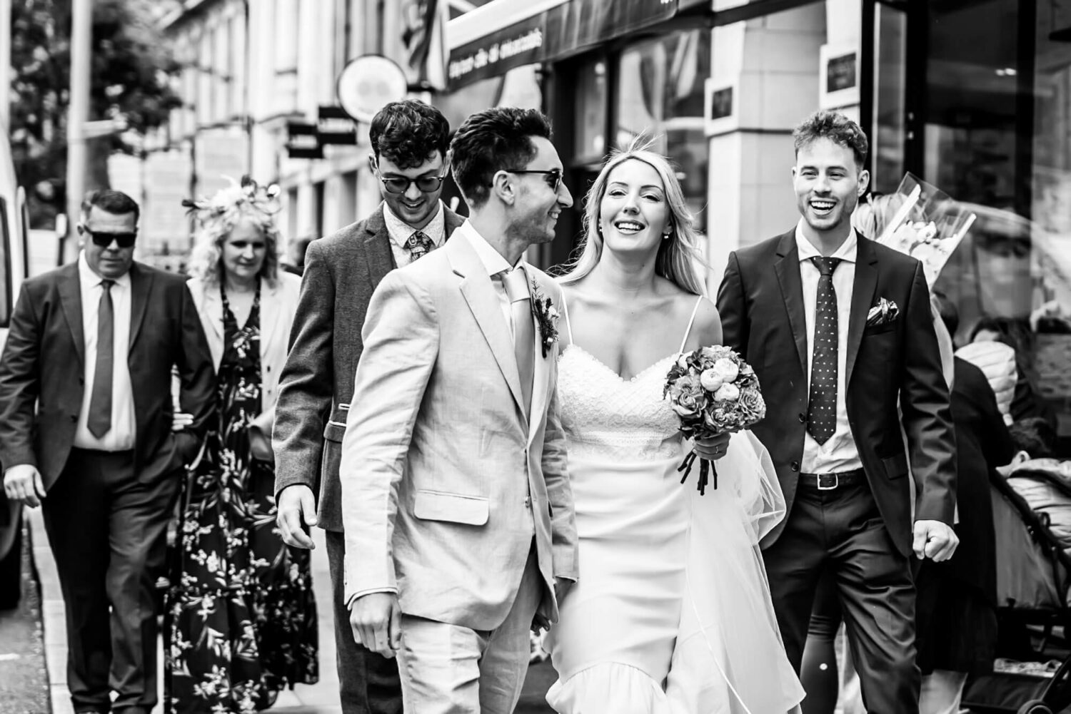 couple and guests walking down kings road london wedding