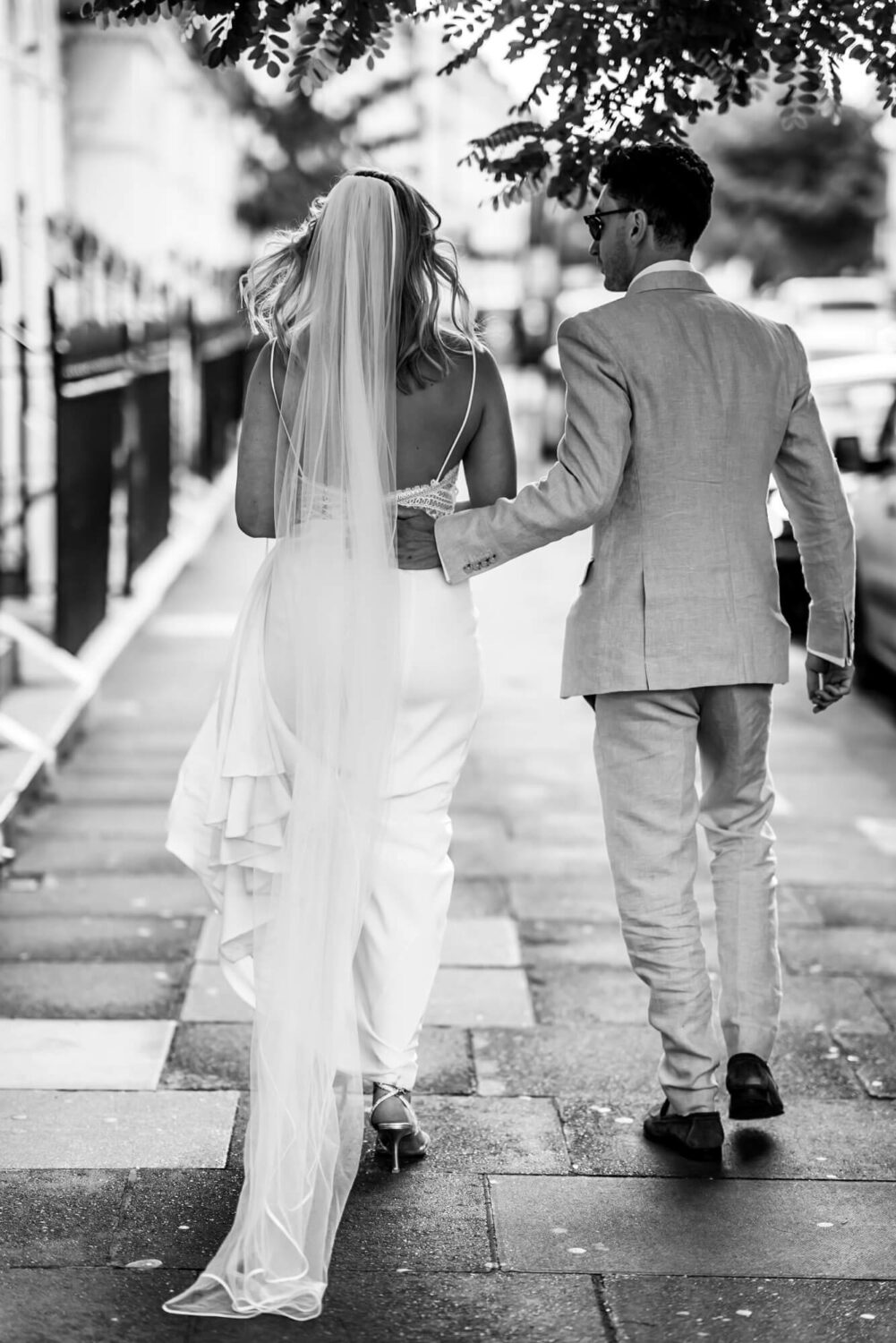 groom puts arms around brides waist london wedding