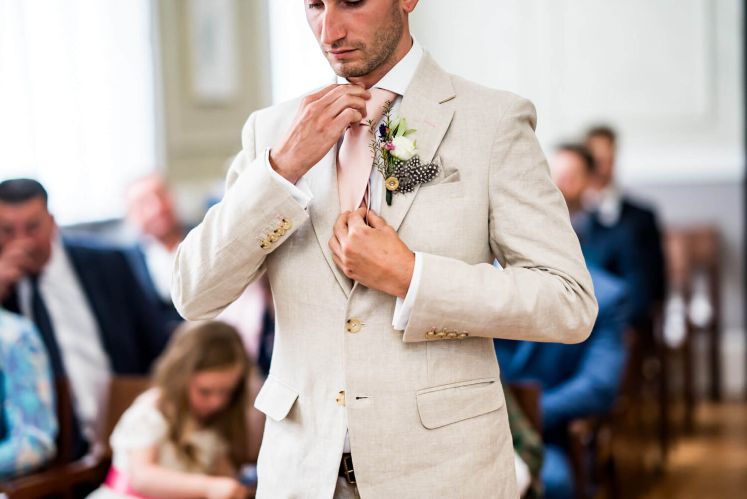 groom straightens his tie london wedding