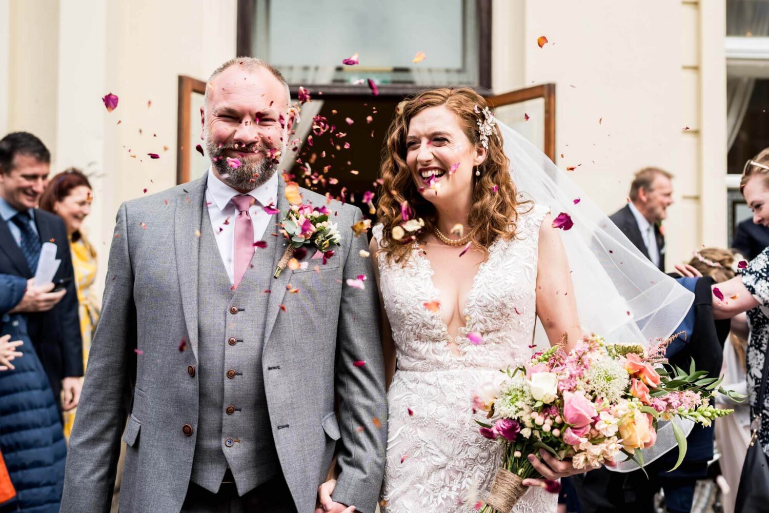 groom and bride walking into confetti