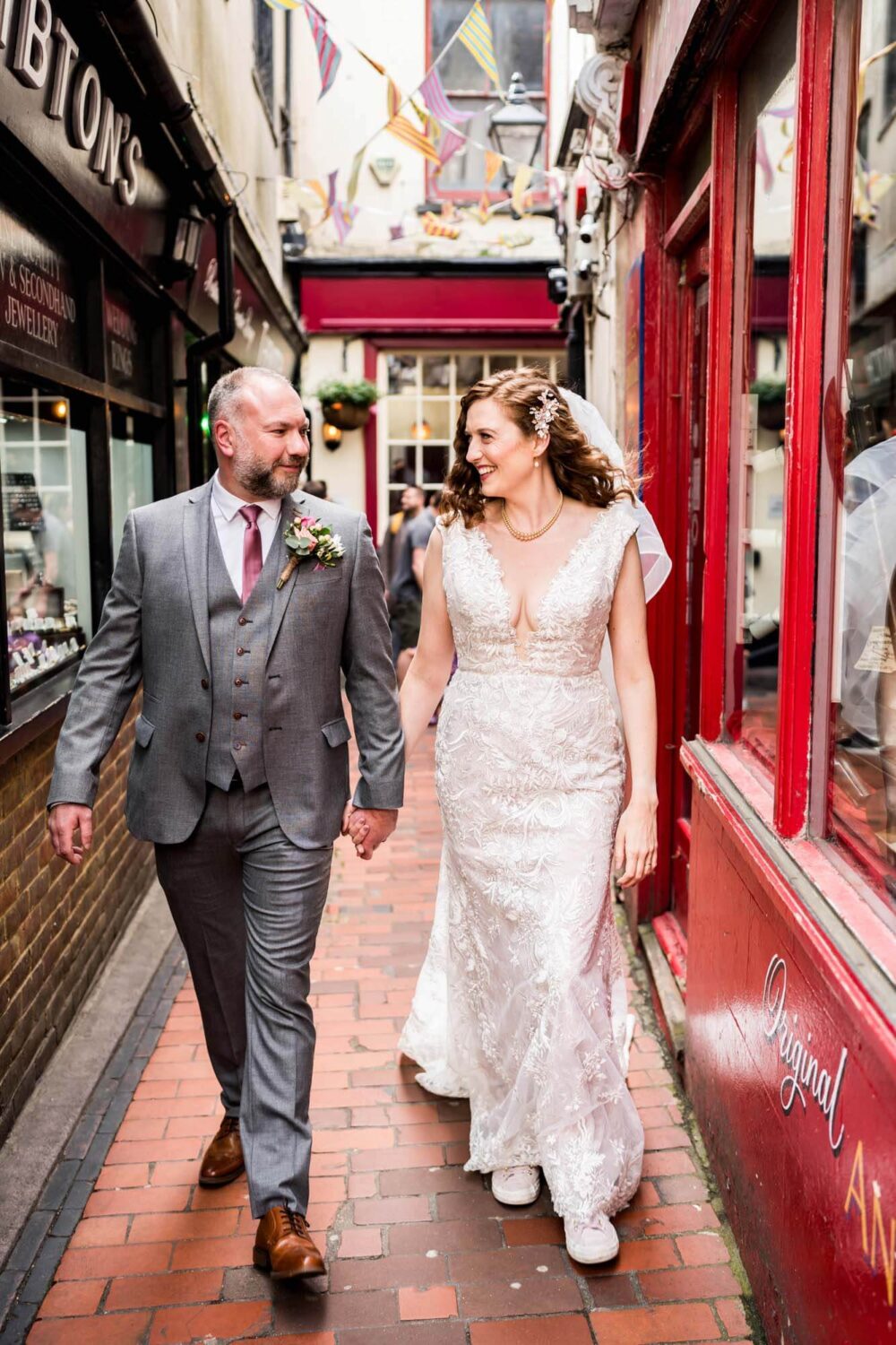 holding hands groom and bride going through north laines