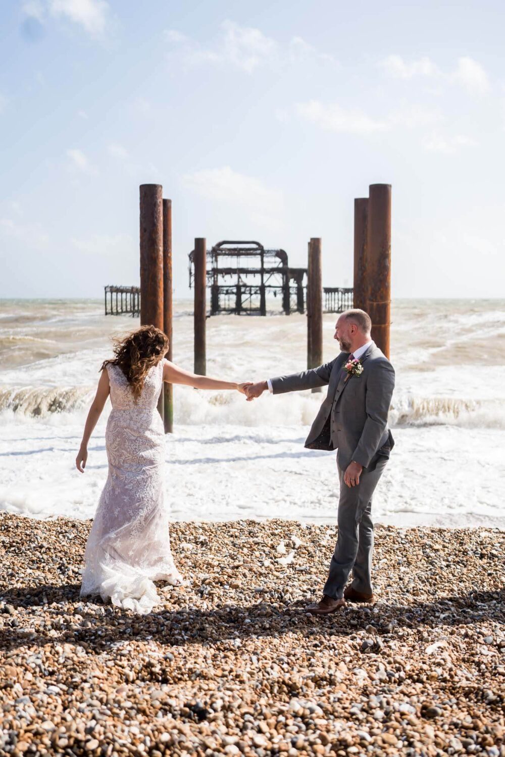 holding hands with west pier behind them