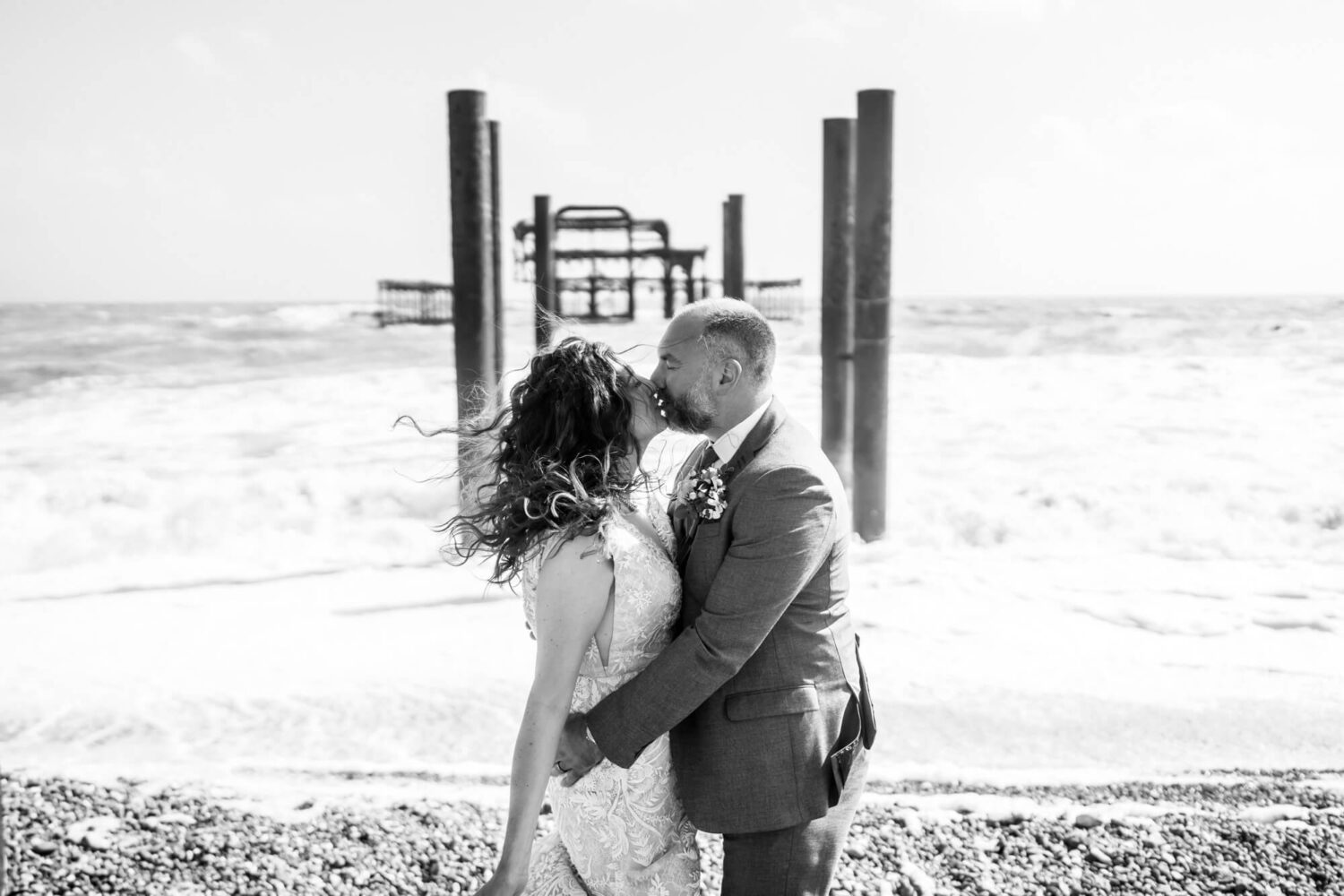 kissing by rough windy seas brighton wedding