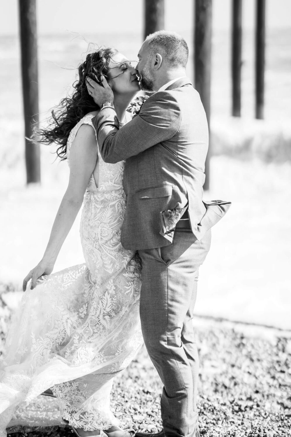 kissing by rough windy seas brighton wedding