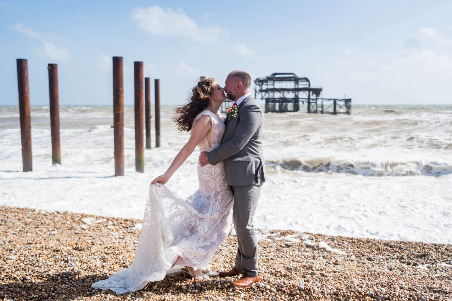kissing by rough windy seas brighton wedding