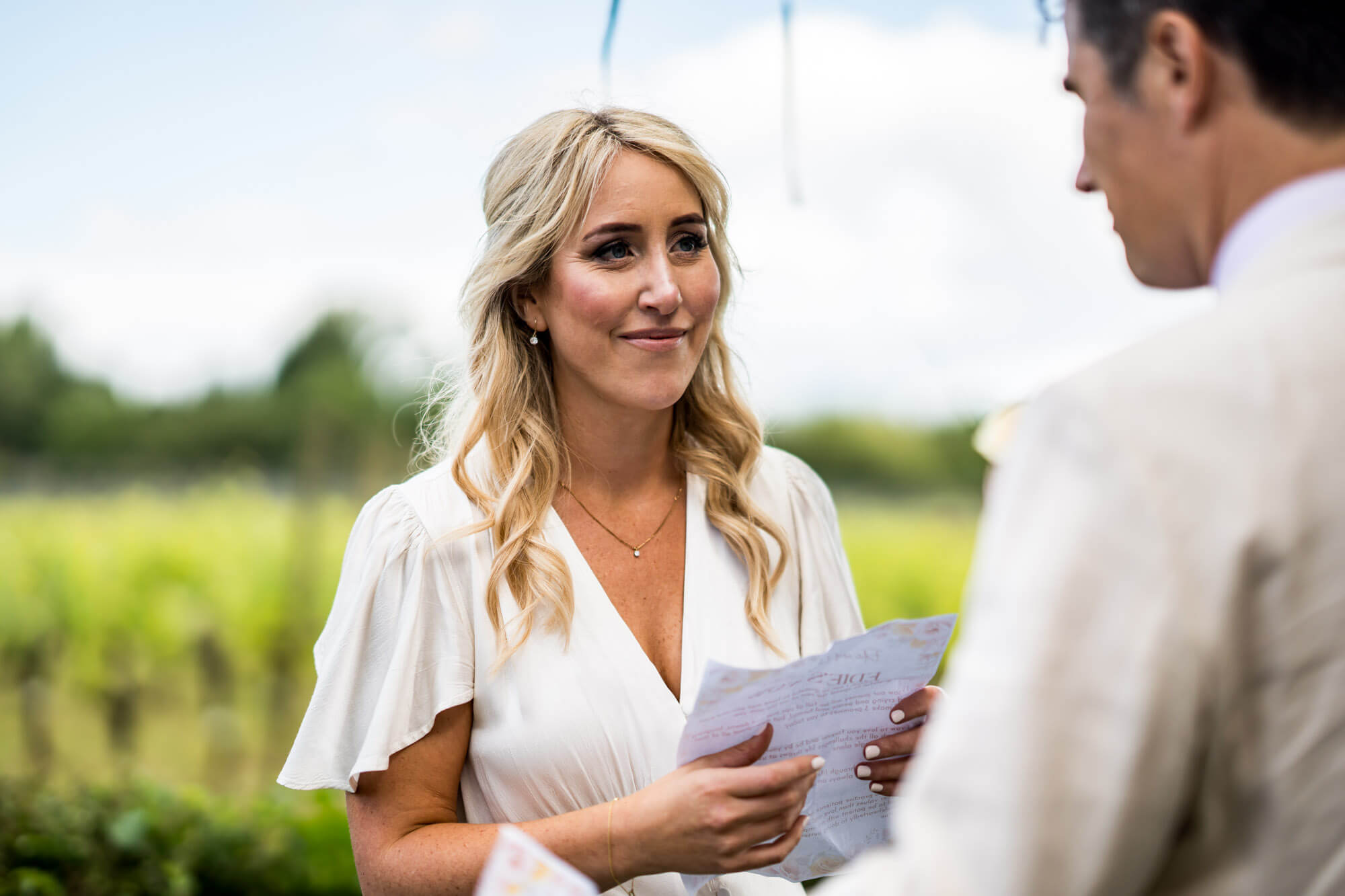 Bride reading paper and looking at groom.