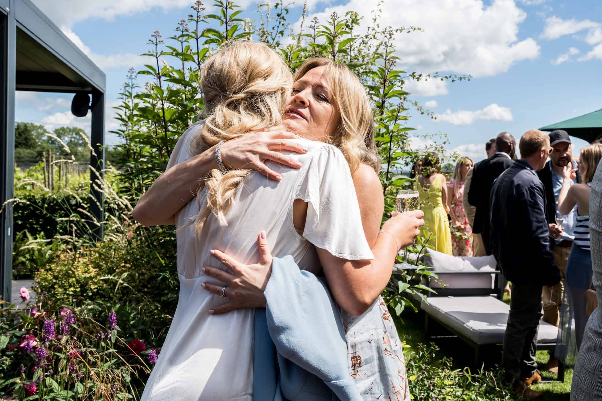 Bride and guest hugging