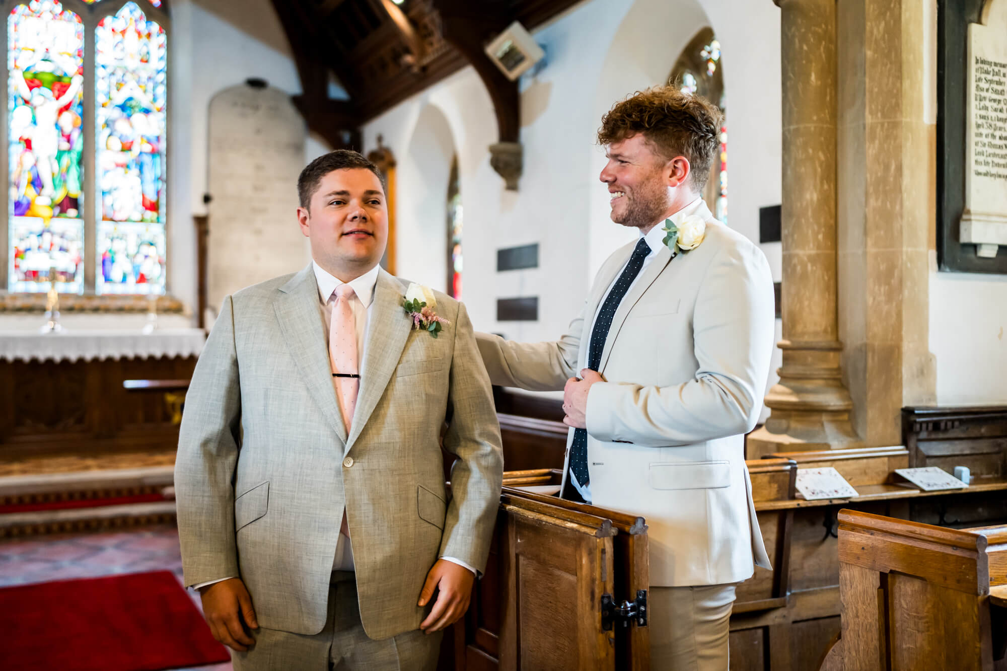 Groom and wedding guest waiting at end of aisle.