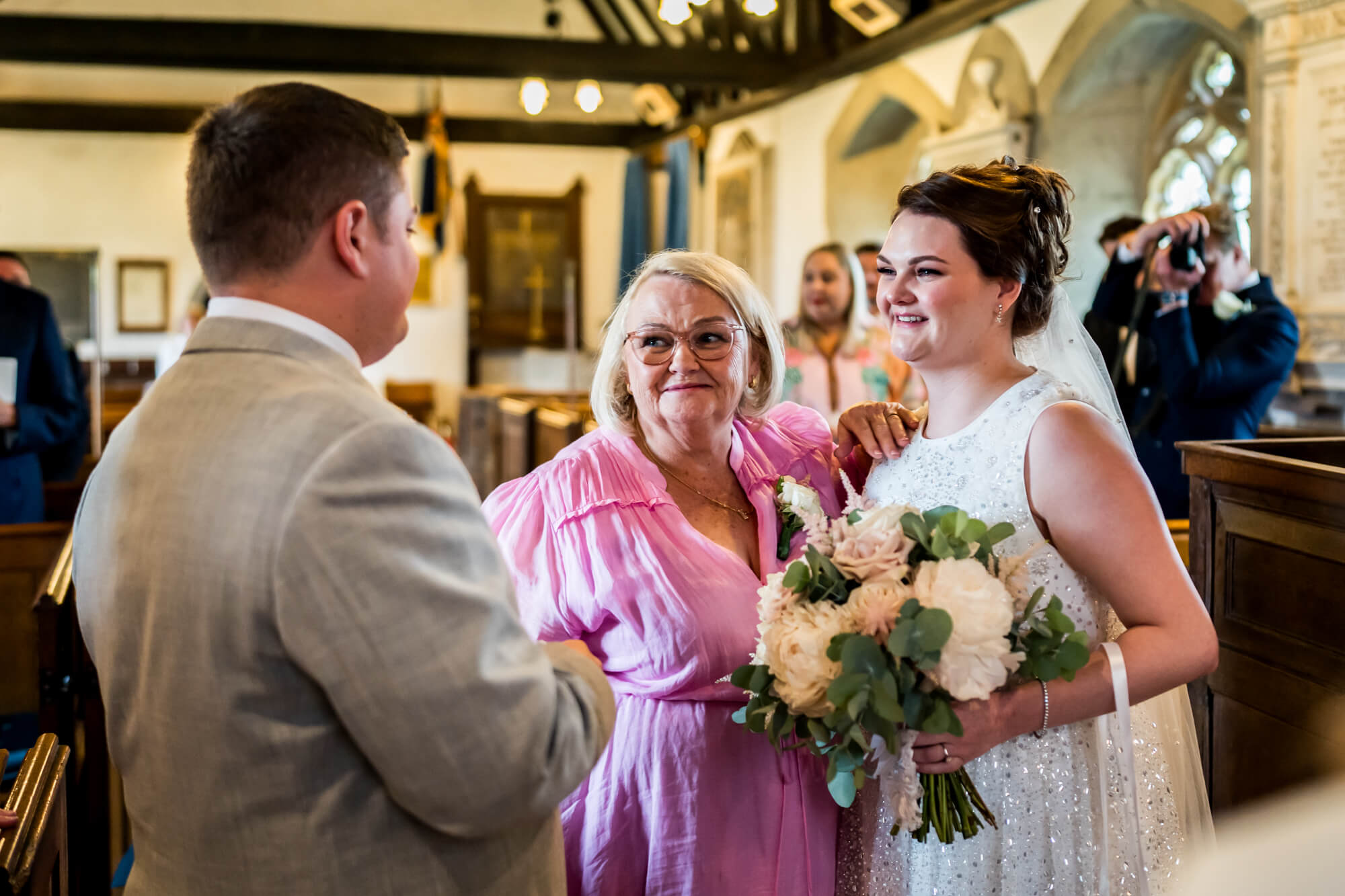 Groom greeting bride and older woman.