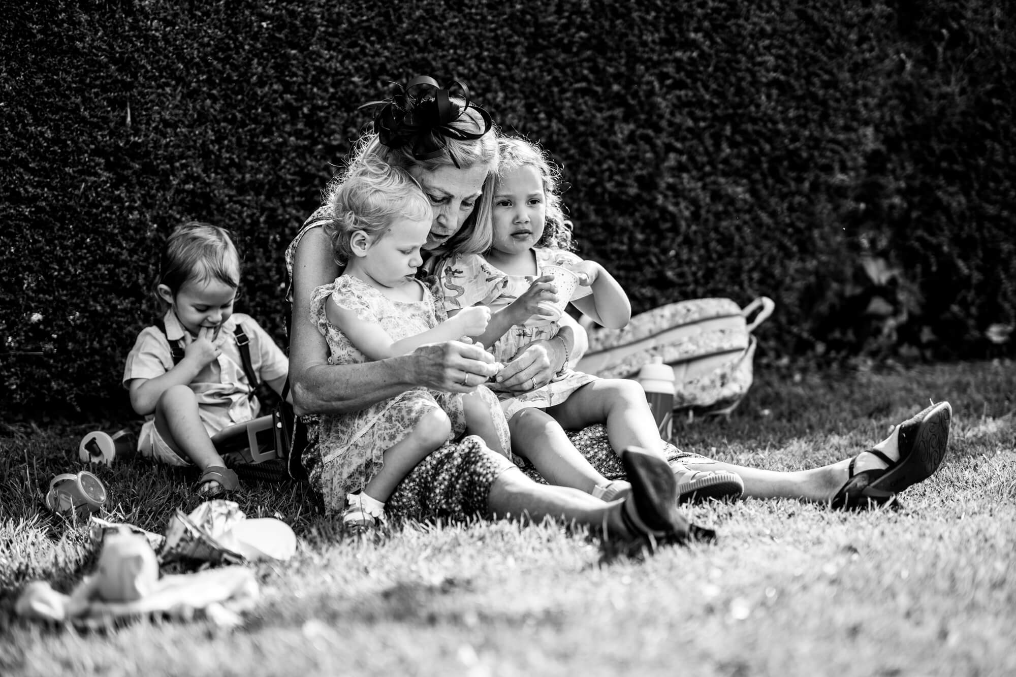 Woman and children sitting on grass - B&W.