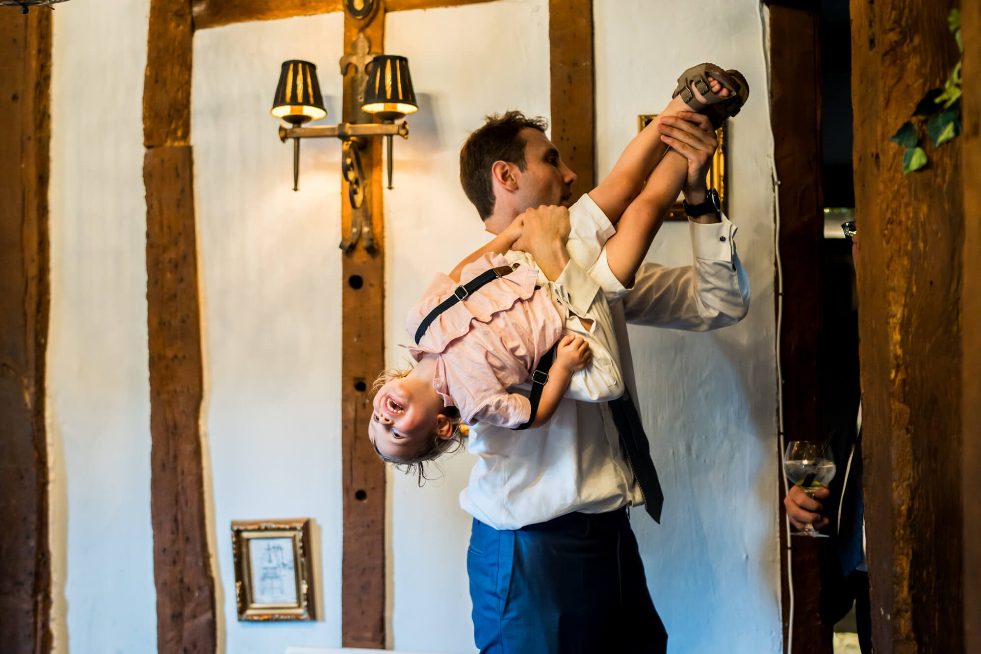Man playfully holding small boy upside down.