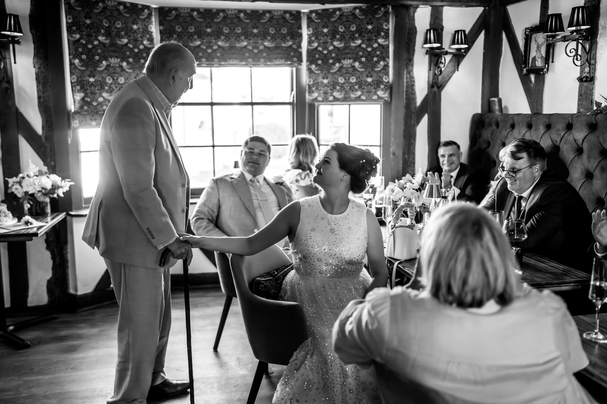 Bride talking to older man in venue - B&W.