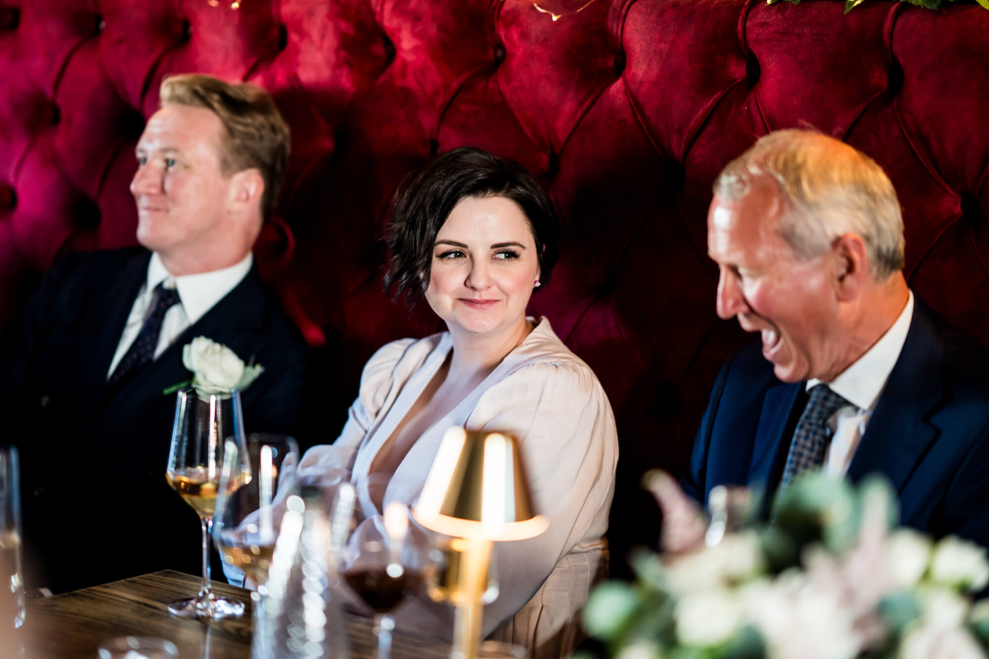 Three wedding guests laughing.
