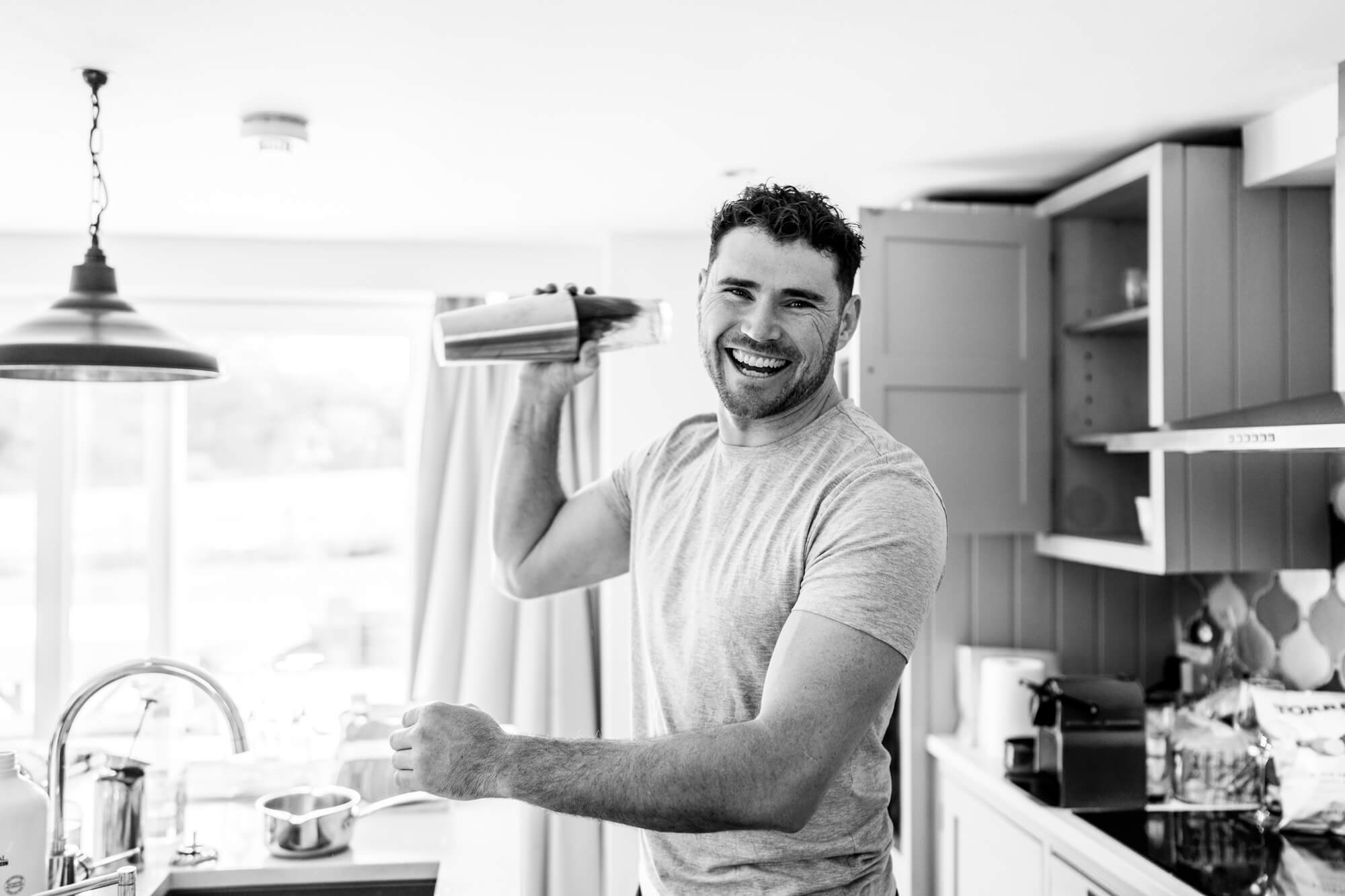 Man preparing drinks in kitchen - B&W.