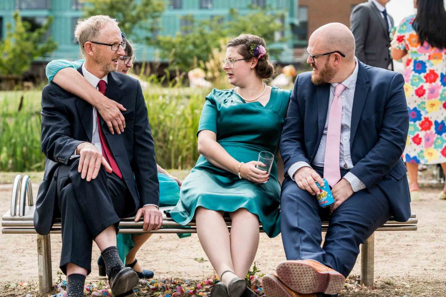 Guests sitting on bench enjoying the reception.
