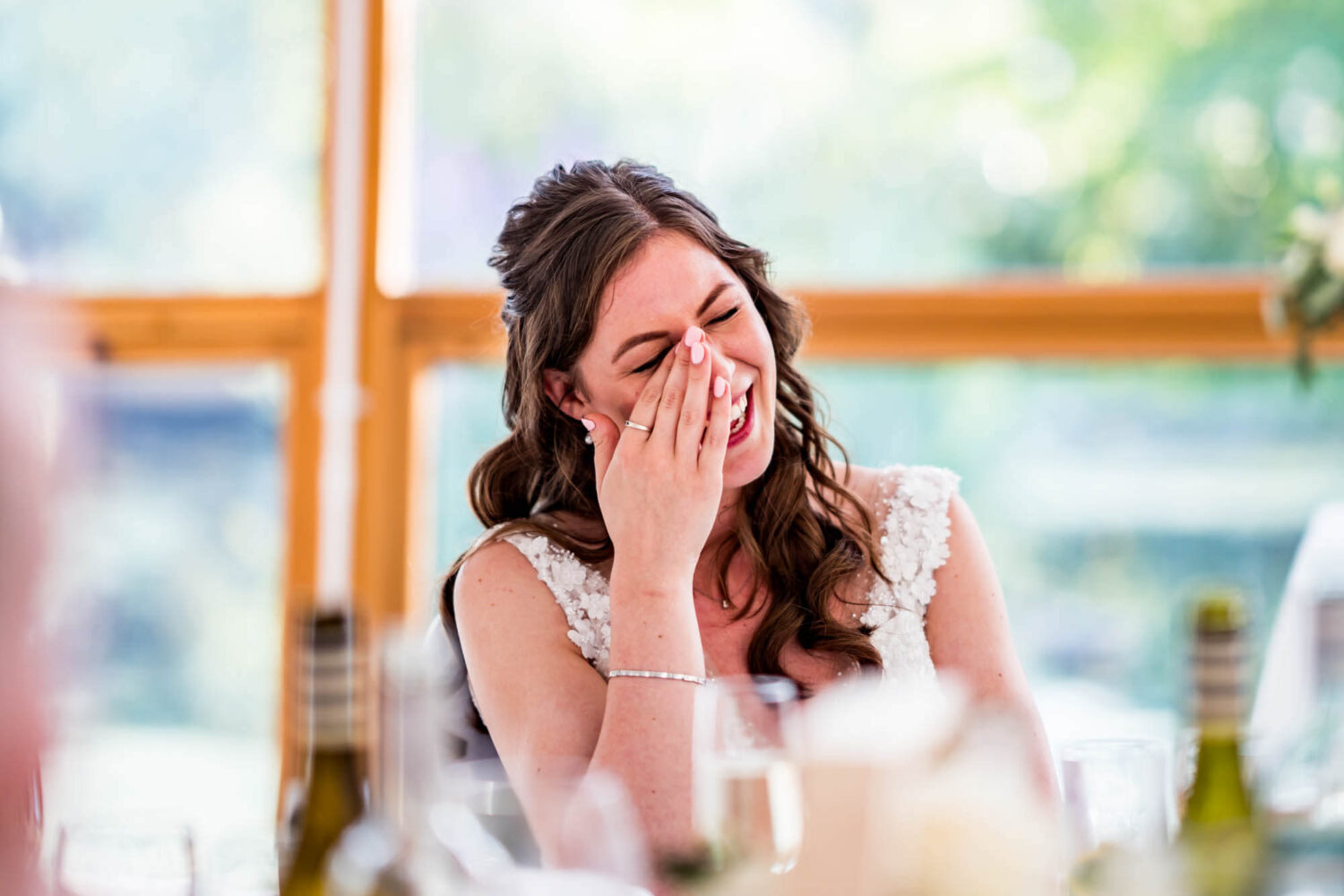 Bride wiping away a tear of laughter during the speeches.