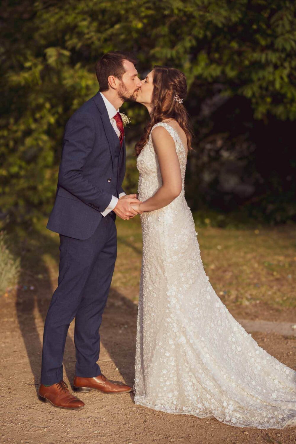 Golden hour shot of bride and groom leaning in for a kiss.