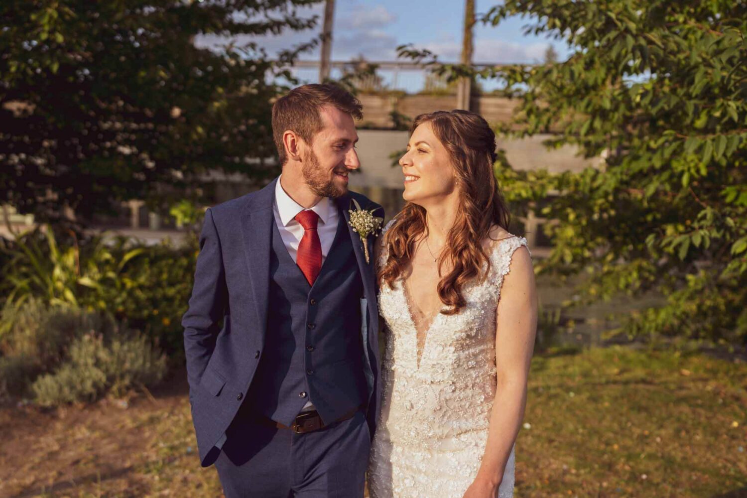 Couple walking towards the camera looking at each other during golden hour.