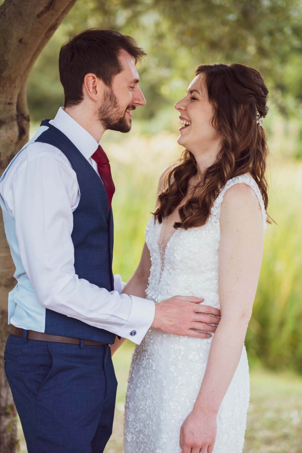 Portrait of groom and bride arms on waist looking at each other.