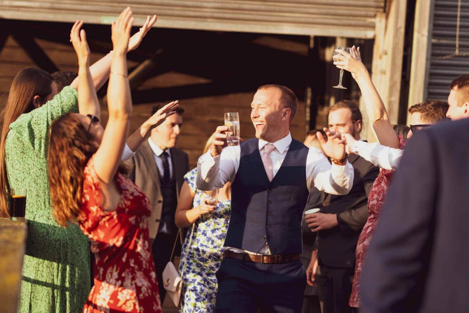 Guest walking through archway of people who have their hands in the air.