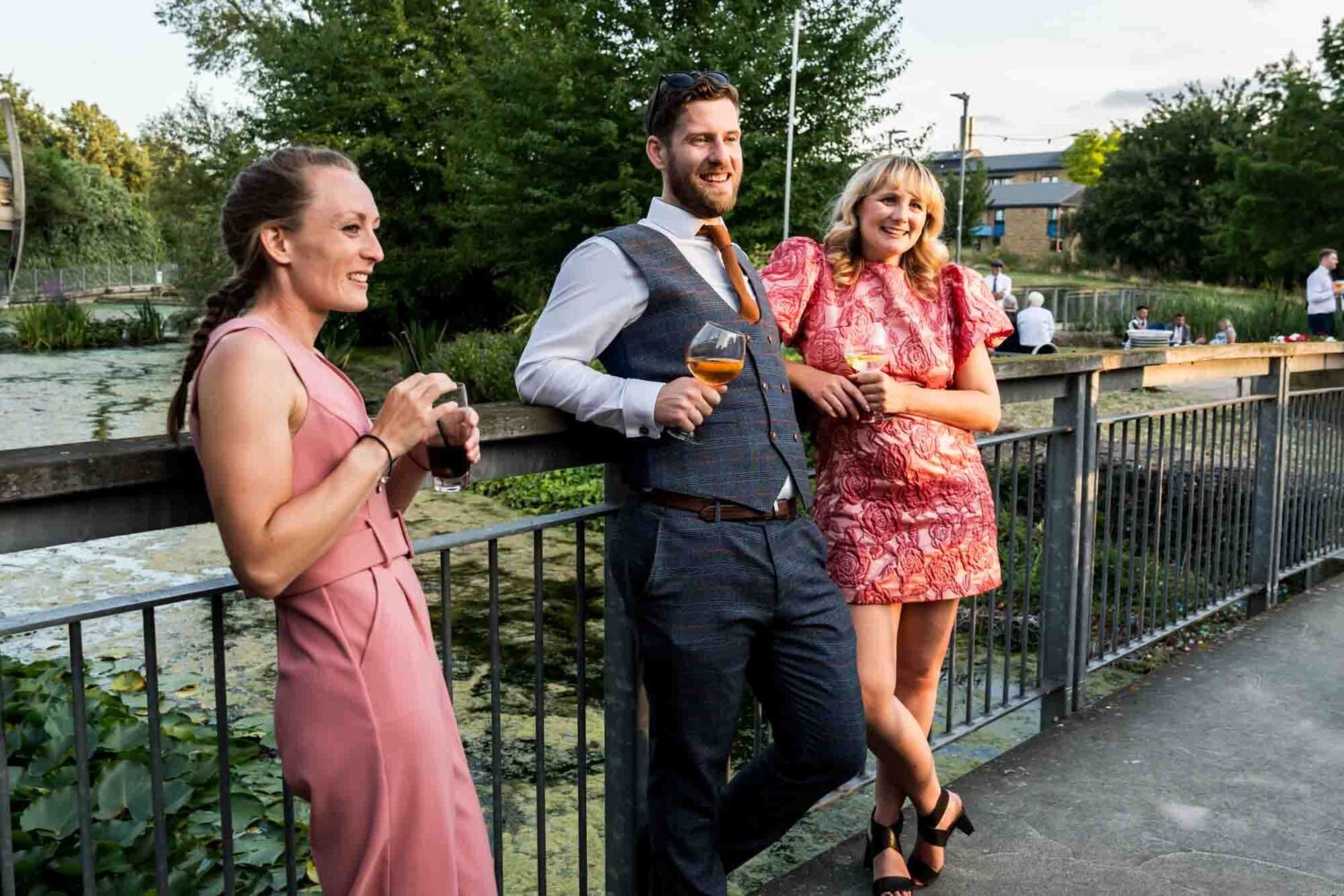 Guests casually standing laughing drinking.