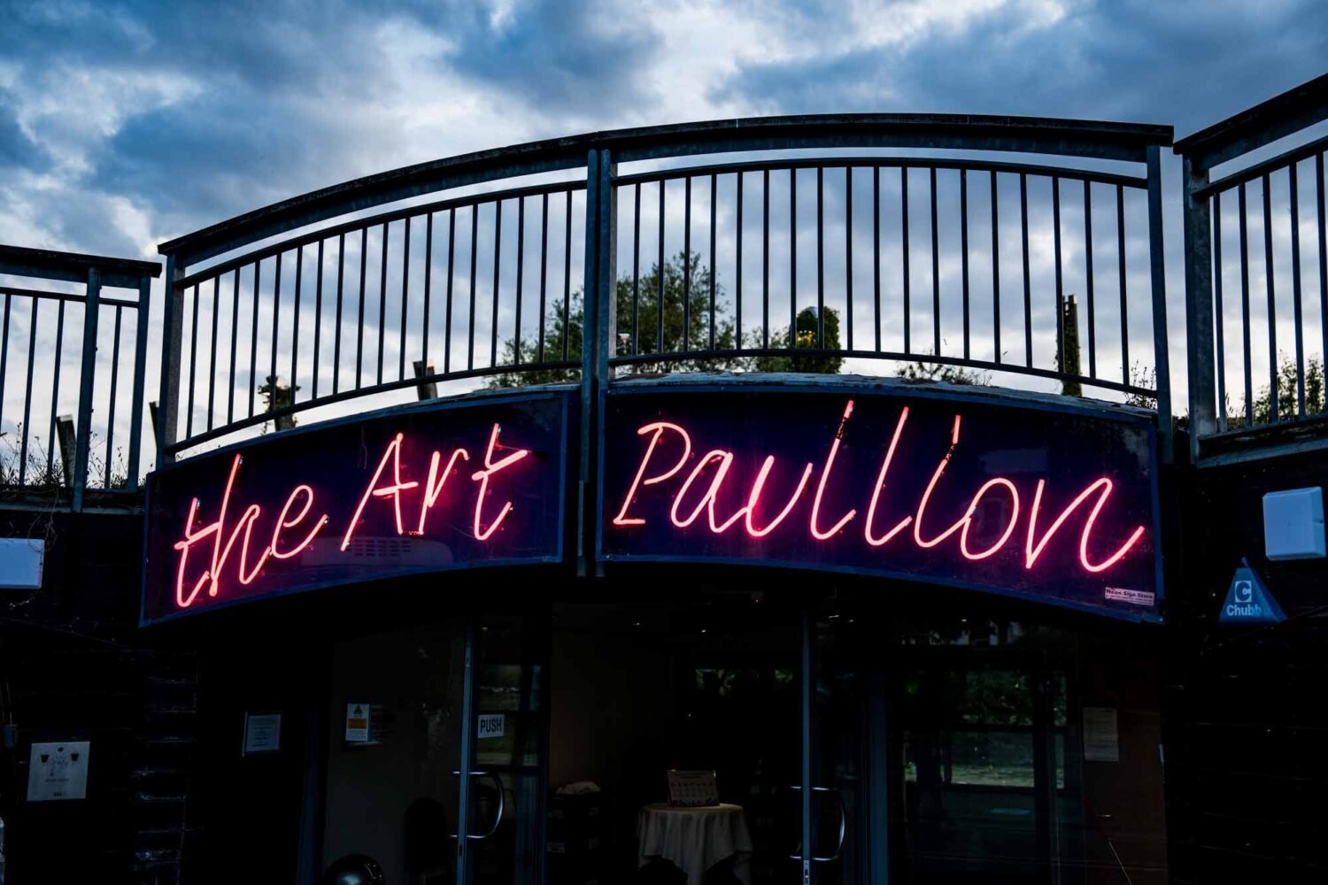 Pic of The Art Pavilion sign at night-time in pink neon light Mile End Art Pavilion wedding photography