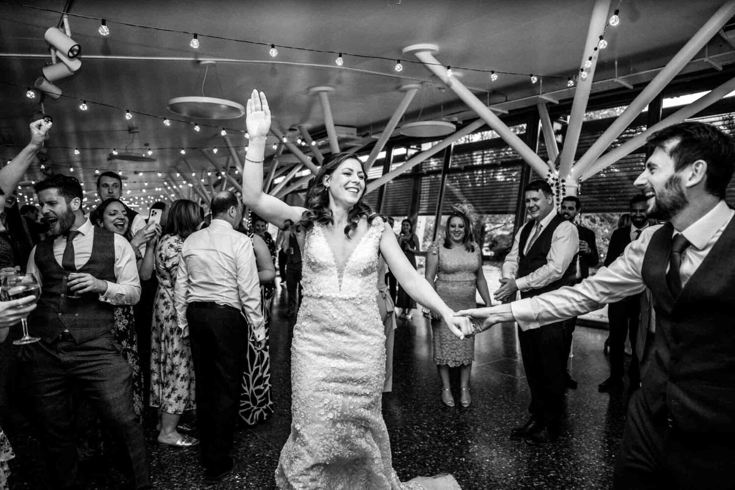 Bride holding hands up during first dance.
