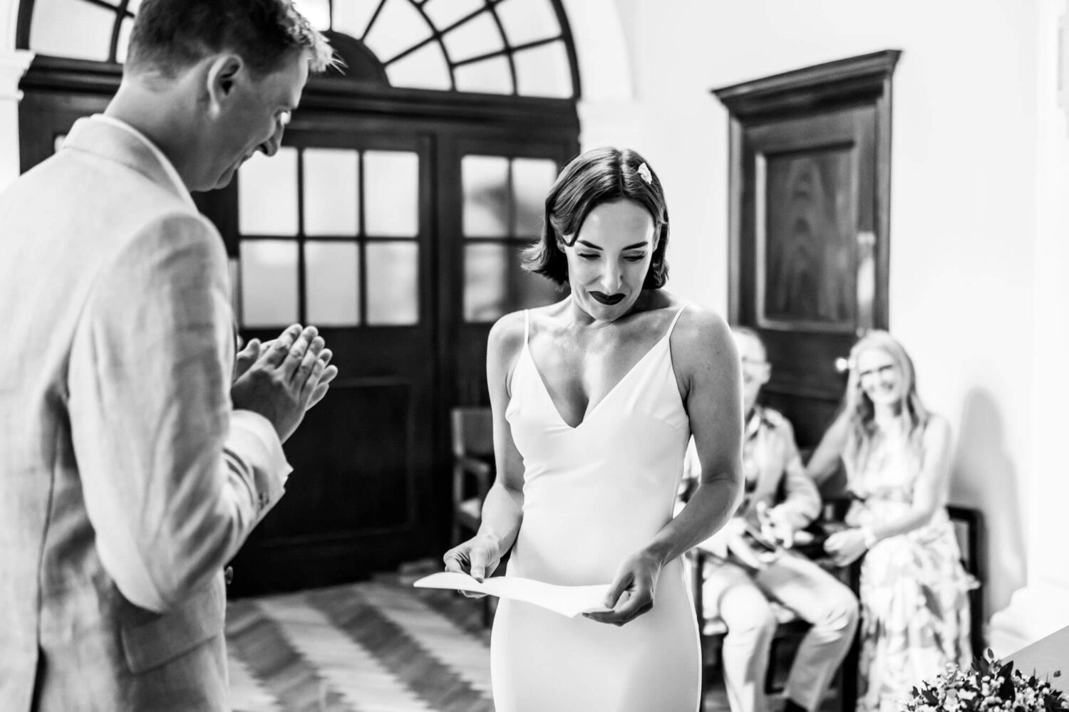 Bride looking bashful while doing reading to groom Chelsea wedding.