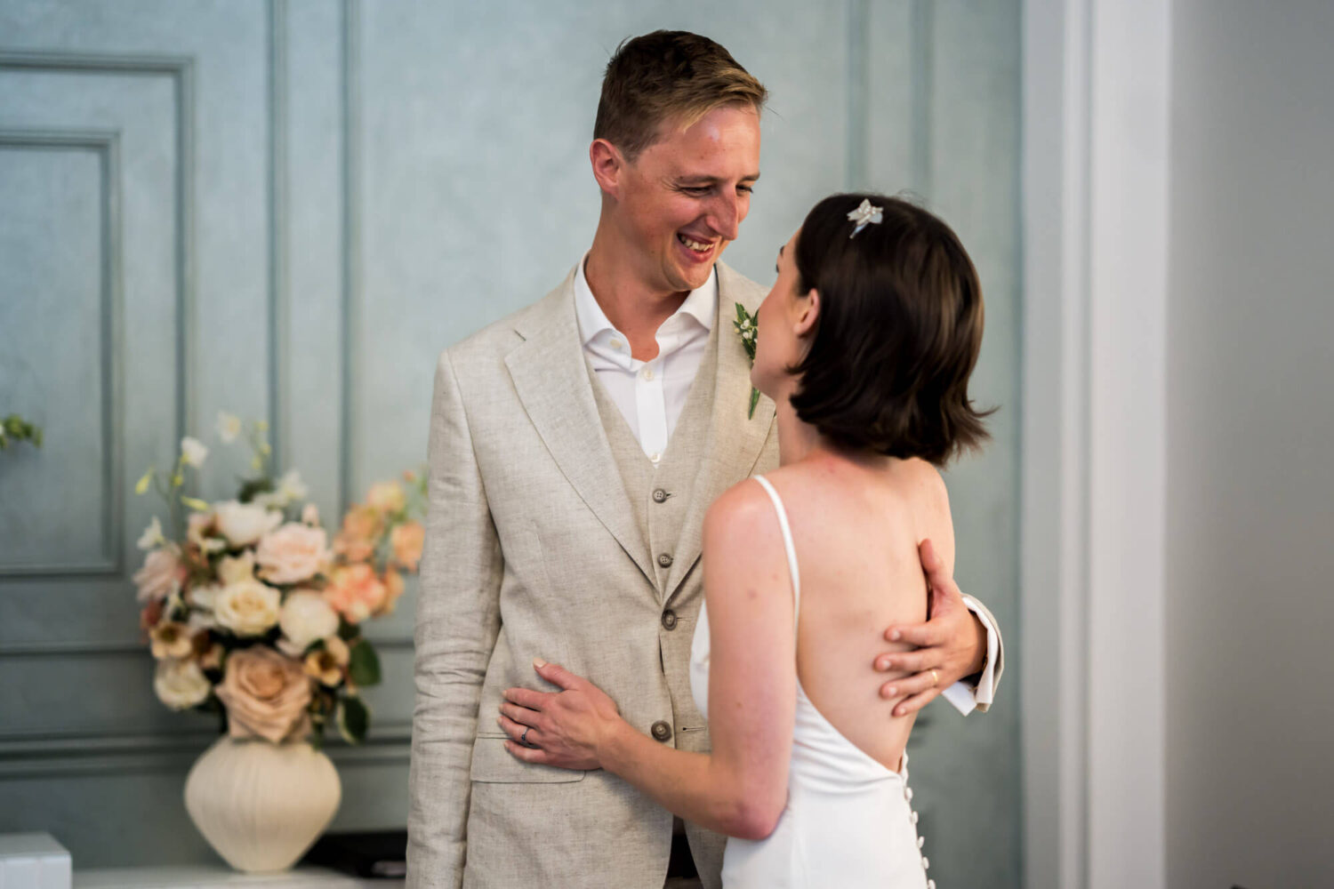 Groom smiling to bride who has her hand on his jacket Chelsea wedding.