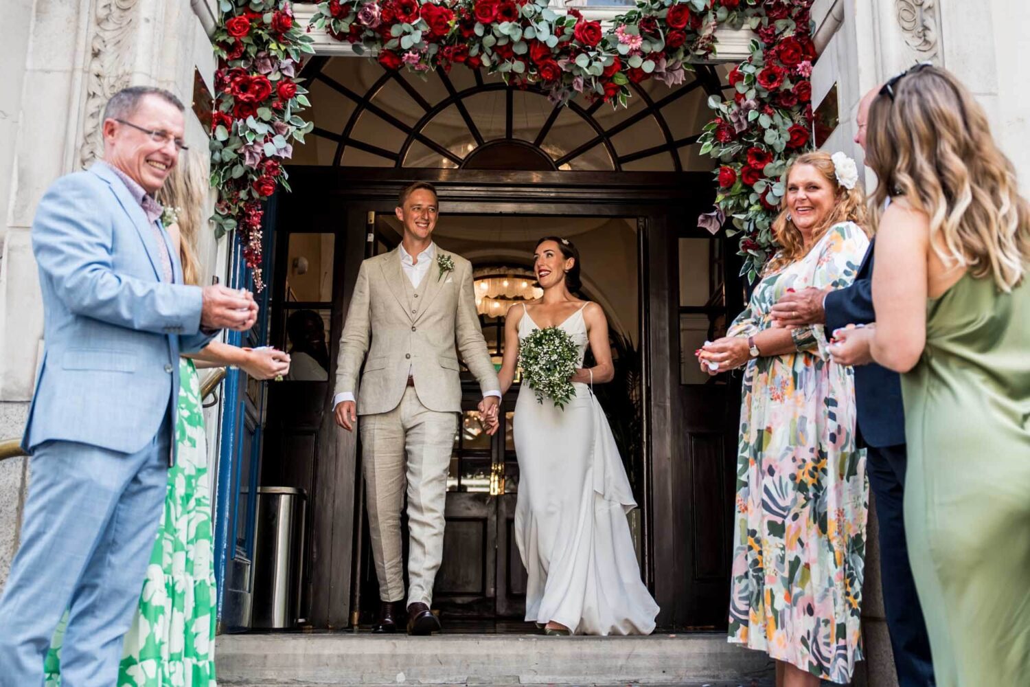 Bride and groom walking out of famous blue Chelsea doors Chelsea wedding.