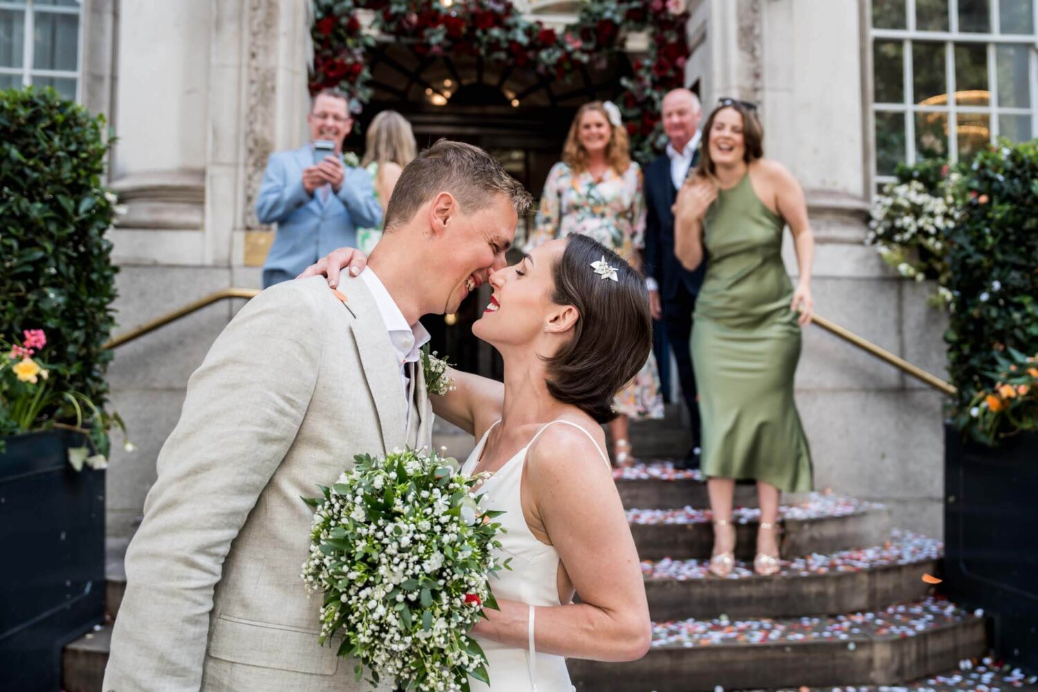 Natural shot of couple kissing outside registry office Chelsea wedding.