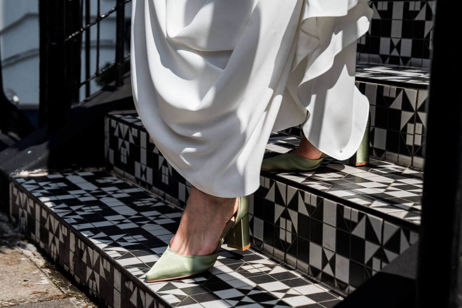 Close up of bride's green shoes walking down steps Chelsea wedding.