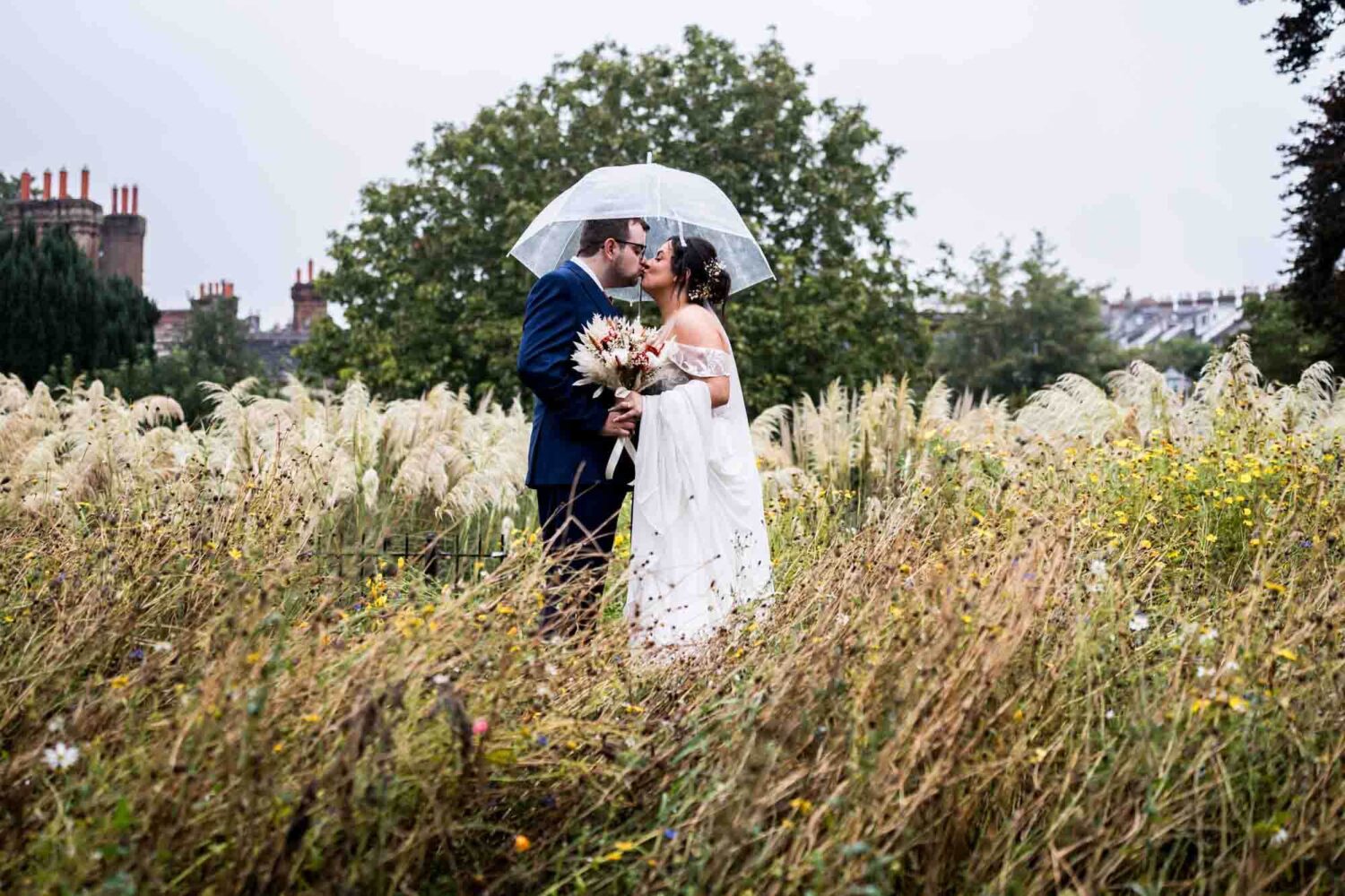 Southover grange gardens bride and groom kissing under an umbrella Lewes wedding.