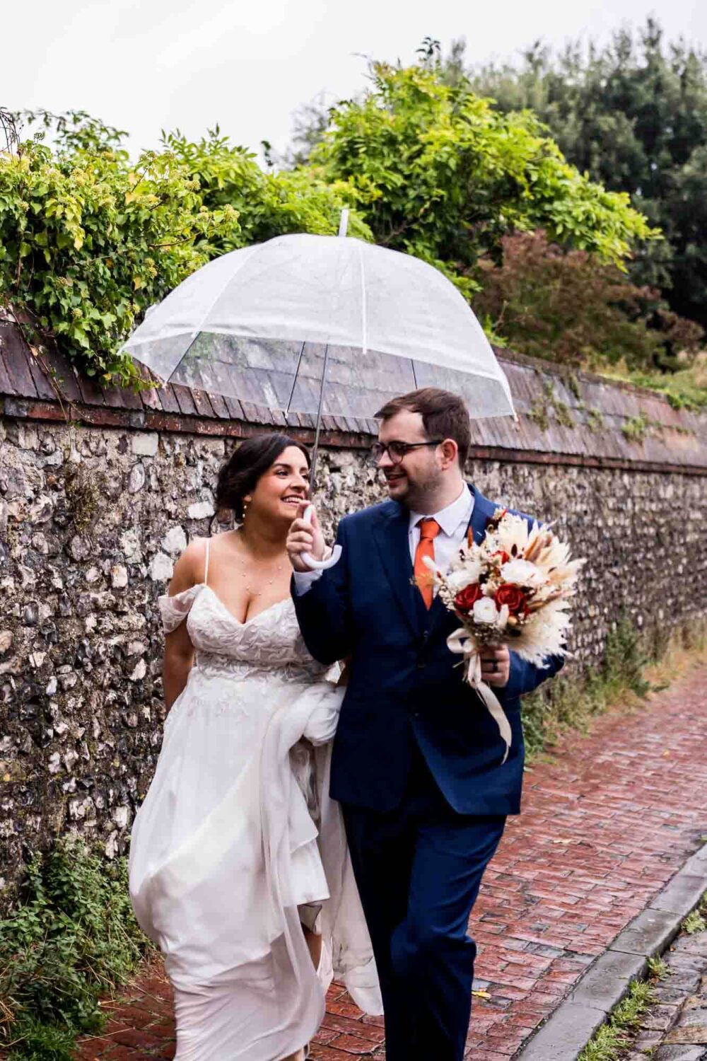 Bride and groom walking through historic Lewes streets Southover grange wedding.
