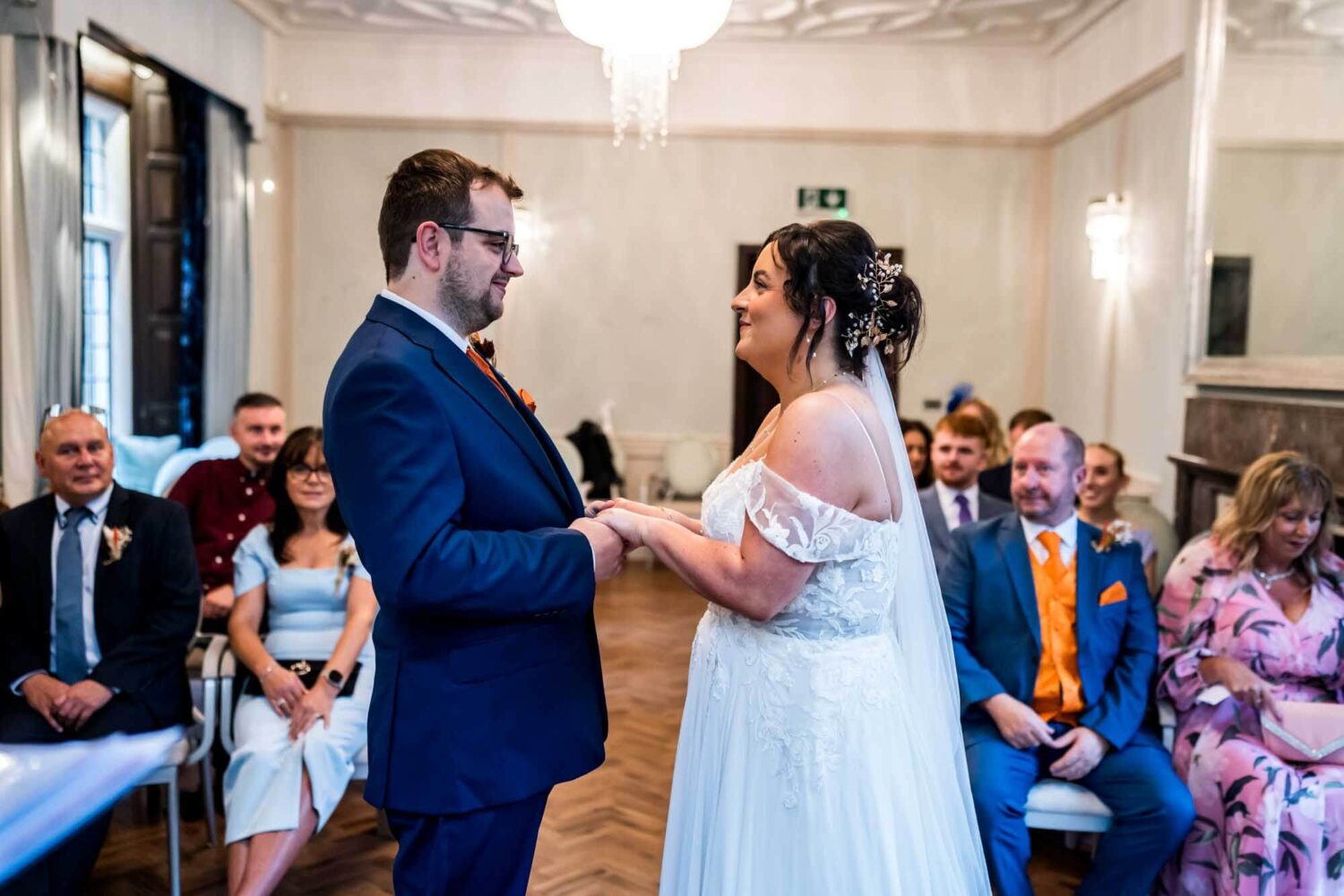 Groom holding bride's hand looking at each other during ceremony Lewes wedding.