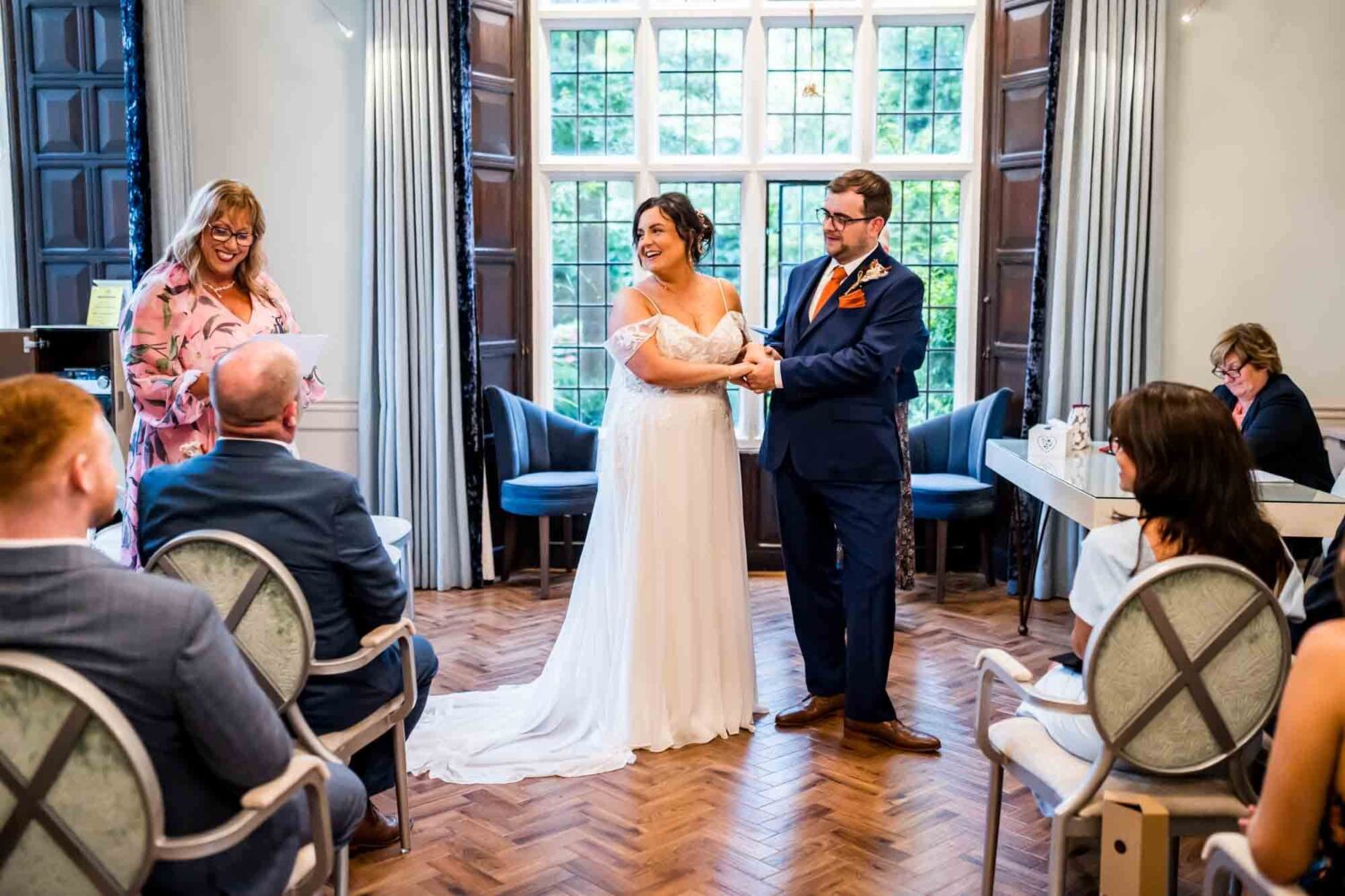 Bride looking over at mother who is reading during wedding ceremony Lewes wedding.