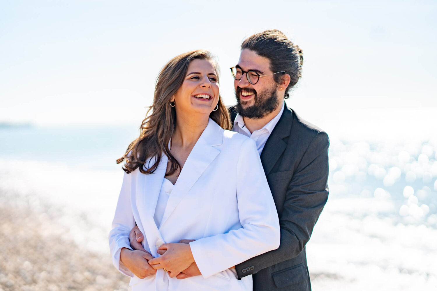 Man standing with arms around woman both smiling Brighton wedding.