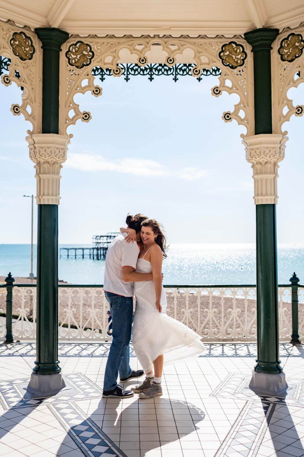 Couple doing a twirl - man and woman - on Brighton bandstand Brighton wedding.